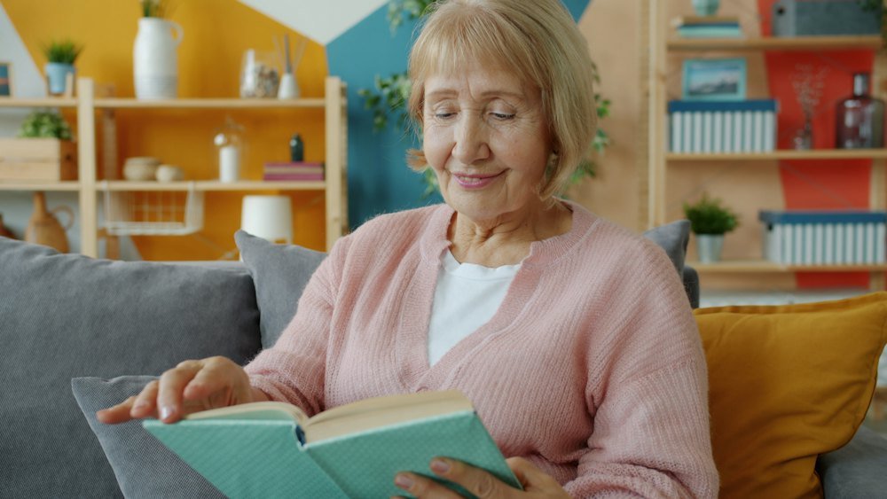Mujer madura leyendo con calma en casa